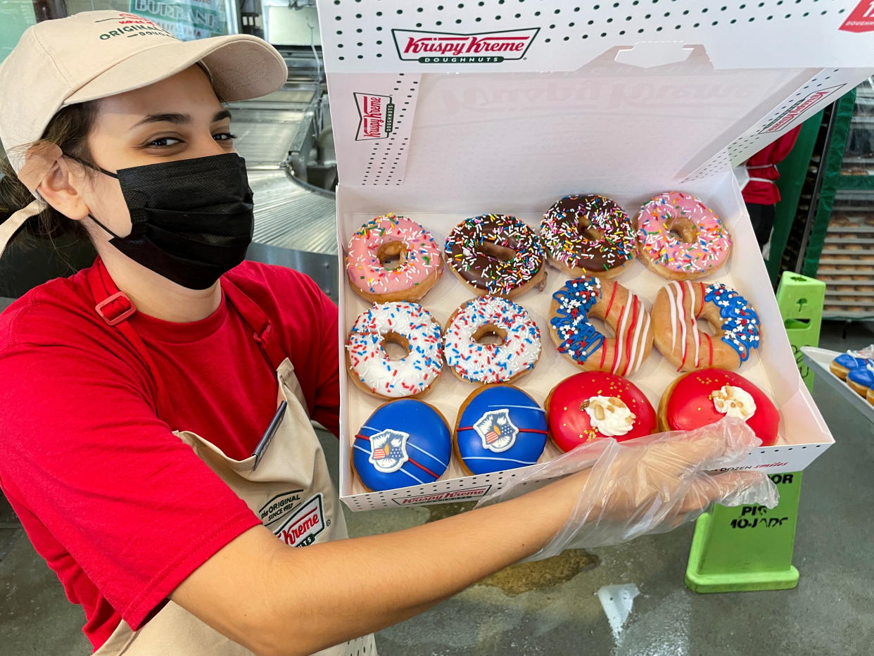 An employee holds a Holiday variety box at a Krispy Kreme Doughnuts store in Burbank, California, U.S., July 1, 2021. REUTERS/Mario Anzuoni