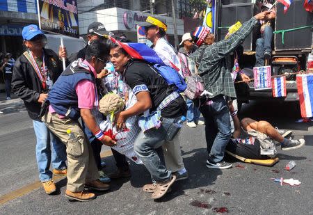 Anti-government protesters help a fellow protester injured in a grenade attack during a rally in Bangkok in this January 17, 2014 file photo. REUTERS/Stringer/Files