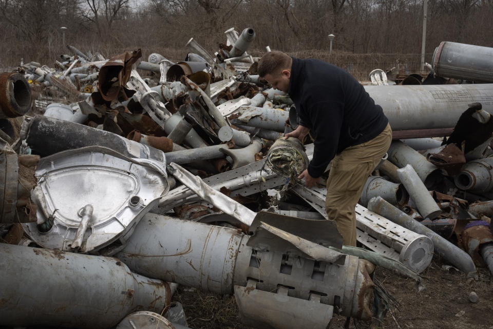 A prosecutor examines fragments of Russian missiles that were collected to investigate Russia's military crimes in Kharkiv, Ukraine, Monday, March 18, 2024. (AP Photo/Efrem Lukatsky)