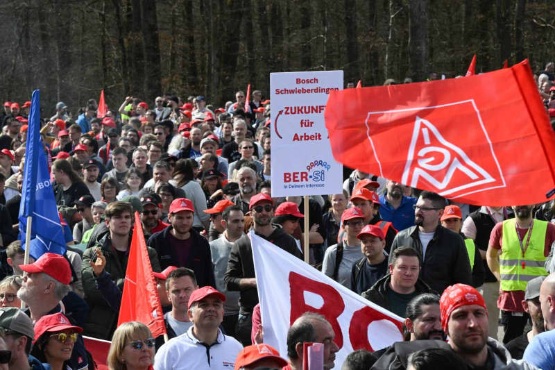 Employees of the Bosch industrial group gather for a rally organized by IG-Metall and the Bosch General Works Council in front of the Bosch headquarters. More than 10,000 employees at German engineering and technology firm Bosch protested outside the company's headquarters on Wednesday against planned job cuts. Bernd Weißbrod/dpa