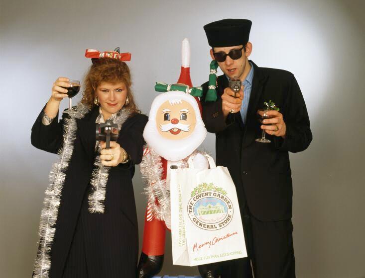 Singers Kirsty MacColl and Shane MacGowan with with toy guns and an inflatable Santa, 1987.