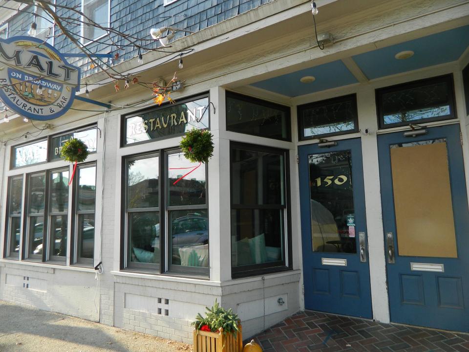 A window is boarded up at Malt restaurant on Broadway, where vandals smashed a window.