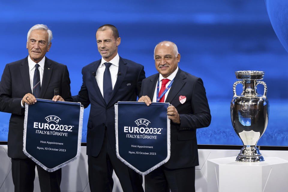 UEFA president Aleksander Ceferin, center, shows the name of Italy and Turkey elected to host the Euro 2032 fooball tournament with Gabriele Gravina, President of the Italian Football Federation (FIGC), left, and Mehmet Buyukeksi, President of the Turkish Football Federation (TFF), right, during the the UEFA EURO 2028 and 2032 hosts announcement ceremony after the UEFA Executive Committee, at UEFA Headquarters, in Nyon, Switzerland, Tuesday, October 10, 2023. UEFA has decided the future of soccer’s European Championship for the next decade. The United Kingdom and Ireland will host in 2028 and an unusual Italy-Turkey co-hosting plan was picked for 2032. (Jean-Christophe Bott/Keystone via AP)