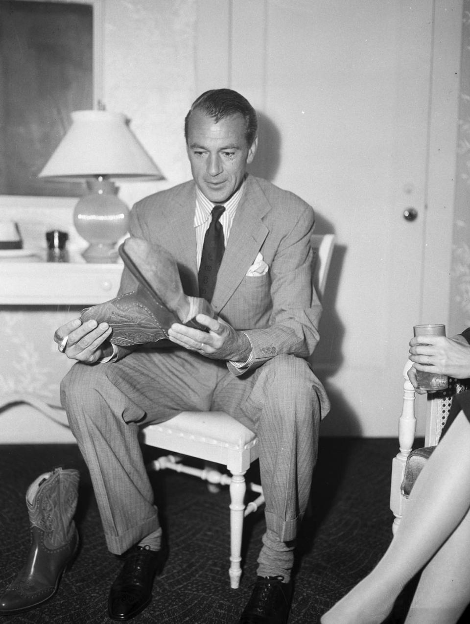 June 18, 1945: Actor Gary Cooper trying on cowboy boots in his Worth Hotel suite in Fort Worth, where he visited for a premier of his film, “Along Came Jones.” He produced and stars in the film. Fort Worth Star-Telegram archives/UT Arlington Special Collections