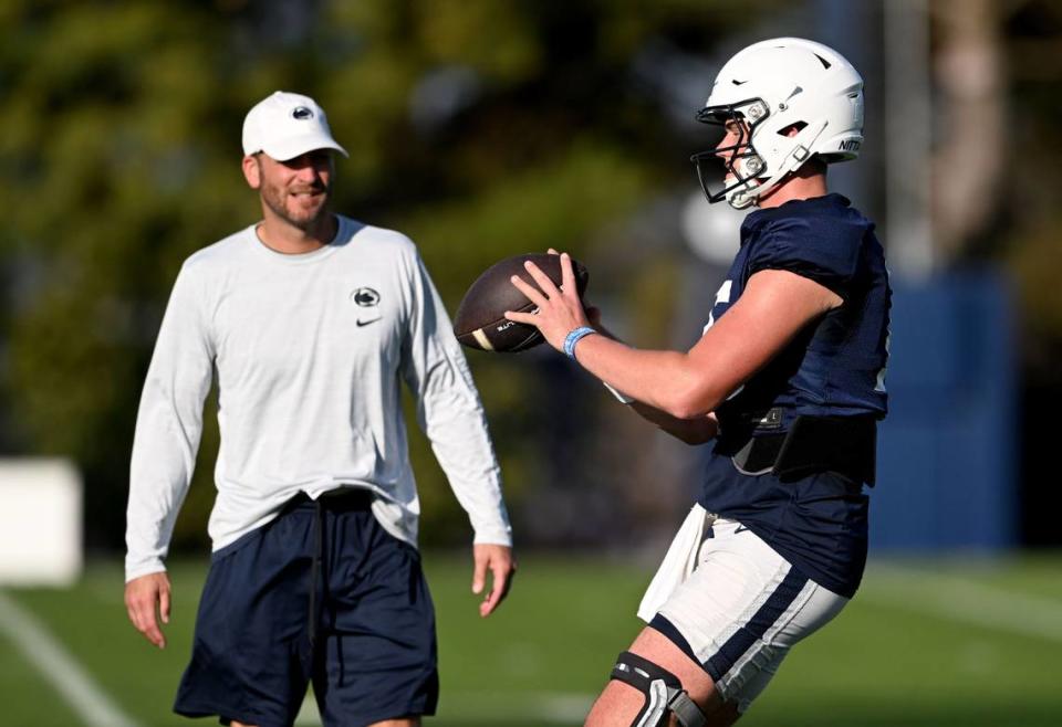 Penn State quarterback Drew Allar drops back to make a pass as offensive coordinator Mike Yurcich watches during practice on Wednesday, Oct. 4, 2023.