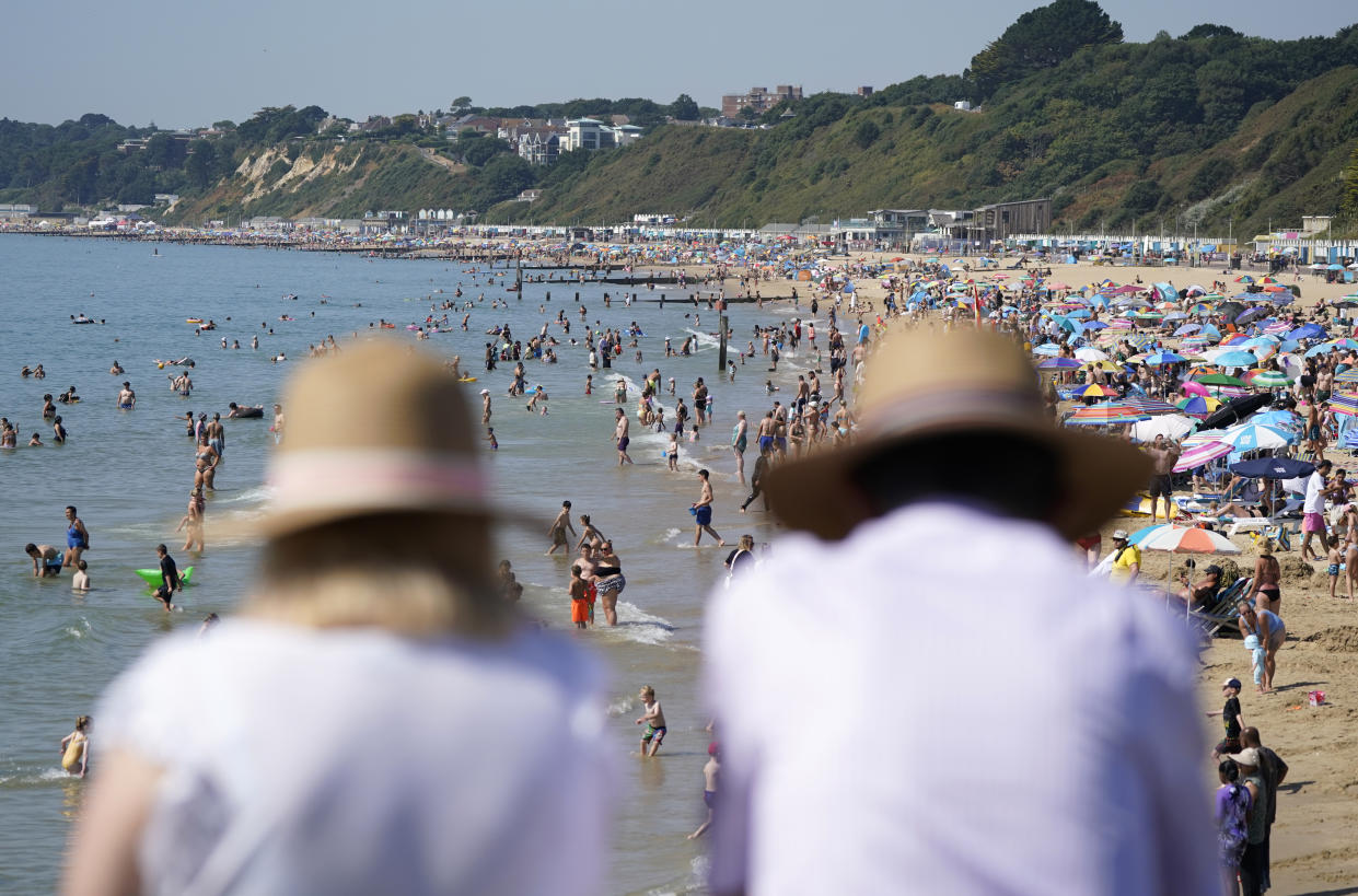 Two people look out from Bournemouth pier as people gather in the hot weather at Bournemouth beach in Dorset. A drought is set to be declared for some parts of England on Friday, with temperatures to hit 35C making the country hotter than parts of the Caribbean. Picture date: Friday August 12, 2022.