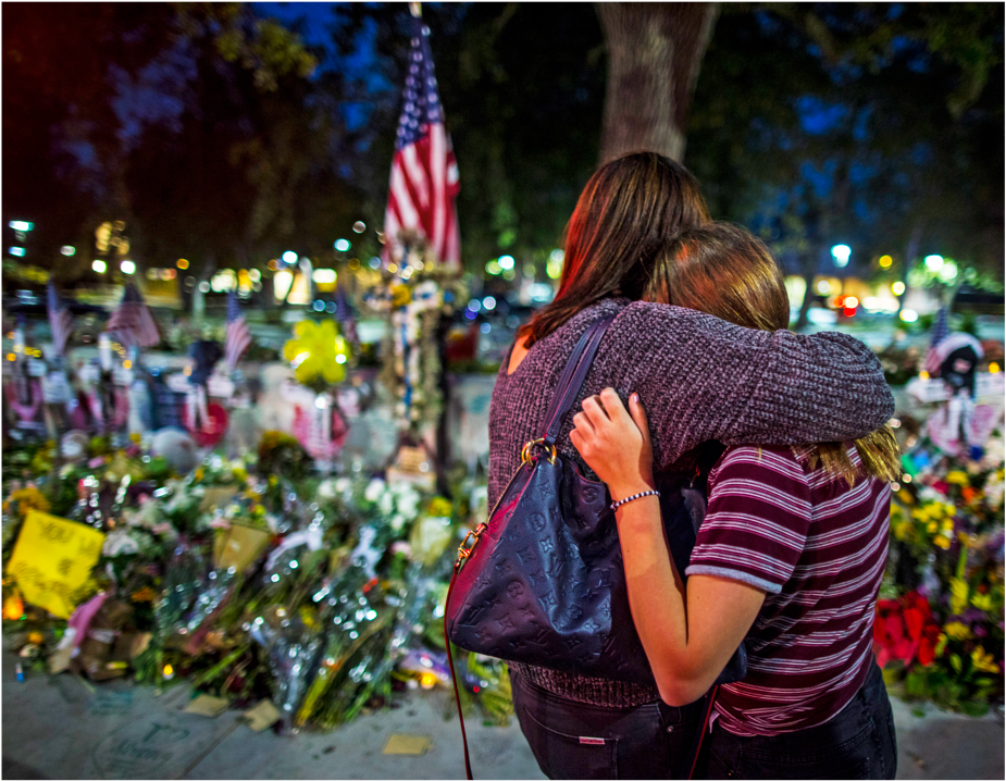 two mourners hugging at the vigil site