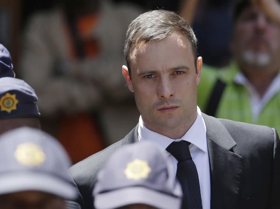 FILE: Oscar Pistorius is escorted by police officers as he leaves the high court in Pretoria, South Africa. Photo: AP