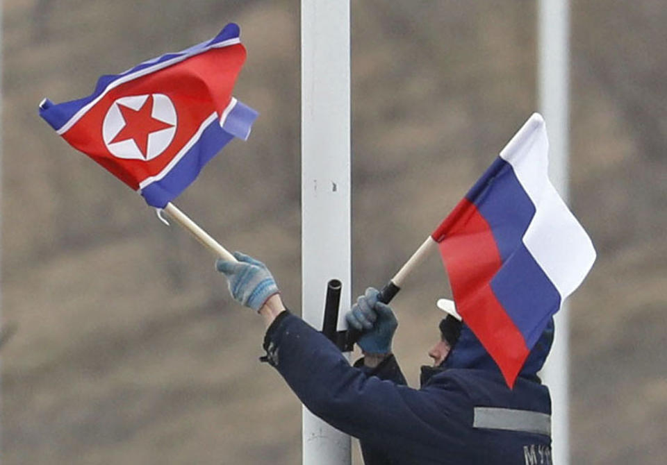 A worker adjusts the flag of Russia and North Korea along the road in Russky Island, off the southern tip of Vladivostok, Tuesday, April. 23, 2019. Preparations are underway for a summit between the leader of North Korea and Russia's president, Russian officials and media reported Tuesday. Russian media have widely reported that the leaders will meet in the port city of Vladivostok on the Pacific Ocean. (Naoya Osato/Kyodo News via AP)