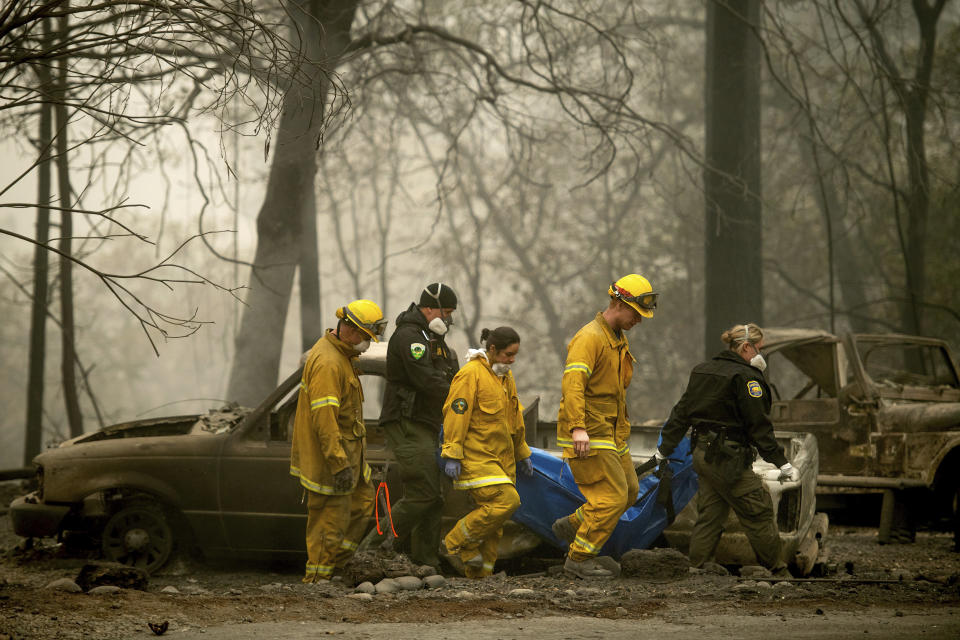 Firefighters recover the body of a Camp fire victim at the Holly Hills Mobile Estates on Wednesday in Paradise, California. Thousands of homes were destroyed when flames hit Paradise, a former gold-mining camp popular with retirees.&nbsp; (Photo: AP Photo/Noah Berge)