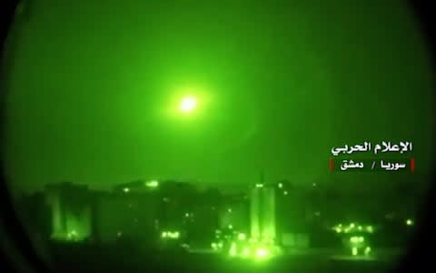 An image grab from a video released on May 10, 2018 by the "Central War Media" and broadcast on Syria's official TV purportedly shows Syrian air defence systems intercepting Israeli missiles - Credit: AFP