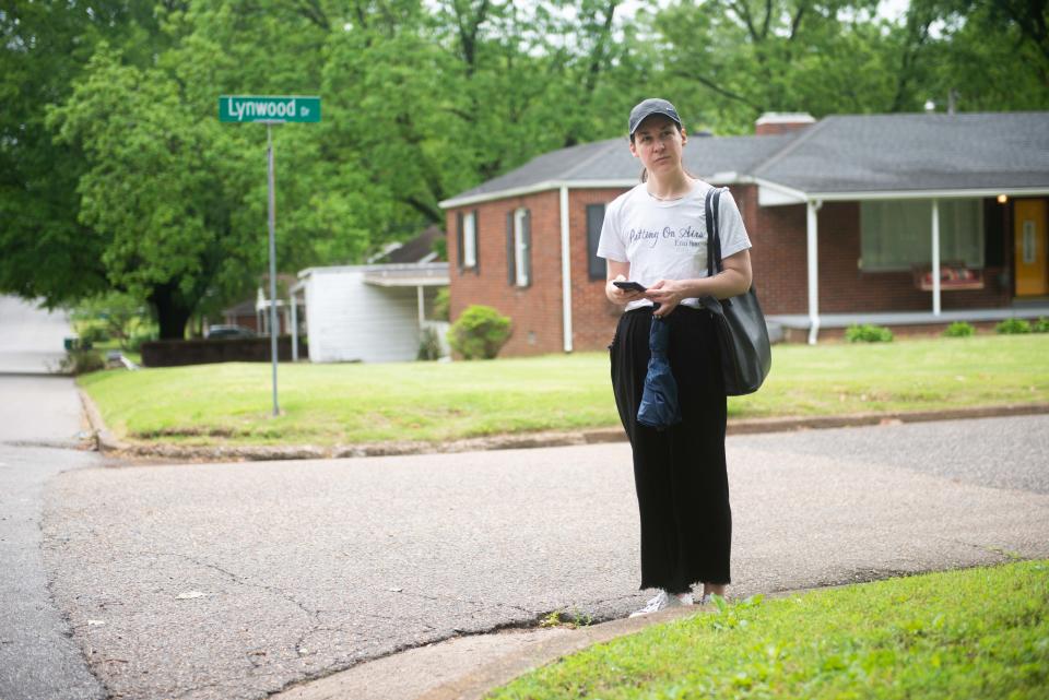 Lauren Smothers, owner of Light Trap Books, waits for the Campbell route bus at an unmarked bus stop on Lynwood Drive on Thursday, May 11, 2023.