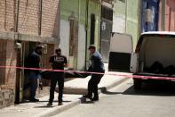 Forensic technicians remove a body from the crime scene where unknown assailants murdered a member of the LGBT community, in Ciudad Juarez
