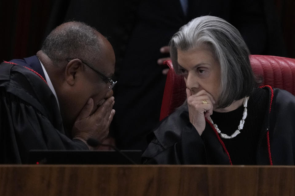 Minister of the Supreme Electoral Court Carmen Lucia, right, talks with Corregidor and Minister Rapporteur Benedito Goncalves during the trial of former President Jair Bolsonaro at the Supreme Court in Brasilia, Brazil, Friday, June 30, 2023. Judges continue evaluating the case which claims Bolsonaro abused his power by using government communication channels to promote his campaign and cast unfounded doubts on the country's electronic voting system. (AP Photo/Eraldo Peres)