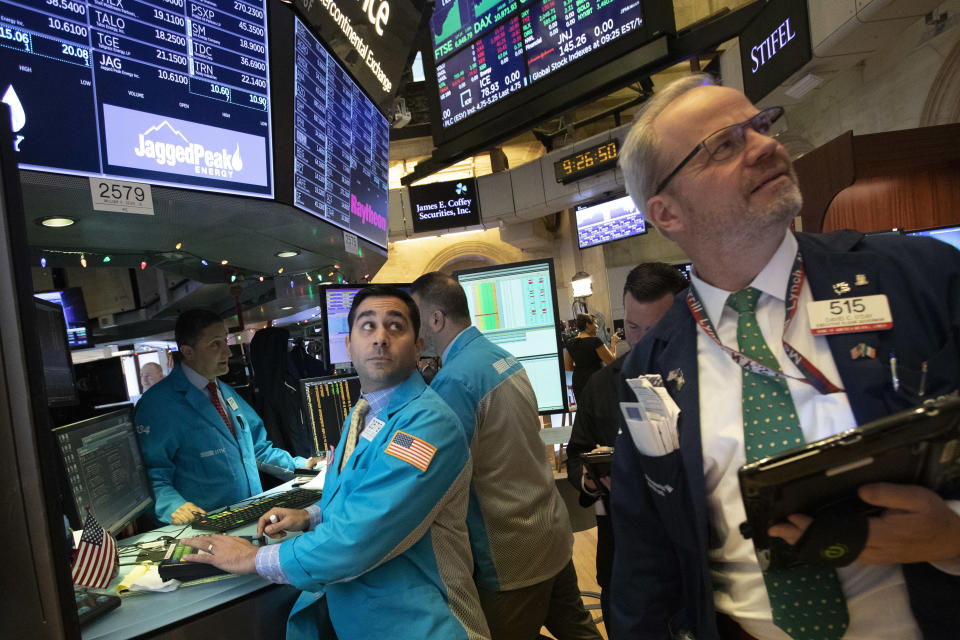 William Geier, Jr., left, and David O'Day work at the New York Stock Exchange, Tuesday, Dec. 11, 2018, in New York. Stock markets around the world spiked higher Tuesday after Wall Street rebounded amid hopes the U.S. and China are back negotiating over their trade dispute. (AP Photo/Mark Lennihan)