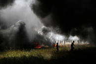 <p>Smoke rises from burning tires as Palestinian demonstrators are seen during clashes with Israeli troops at the Israel-Gaza border at a protest demanding the right to return to their homeland, in the southern Gaza Strip, April 6, 2018. (Photo: Ibraheem Abu Mustafa/Reuters) </p>