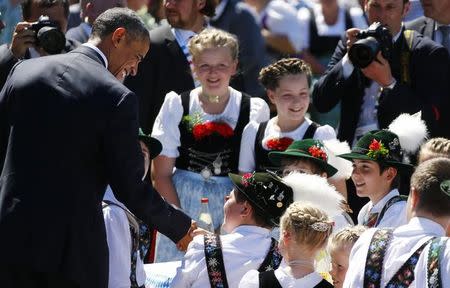 U.S. President Barack Obama talks with children dressed in traditional Bavarian attire as he walks the streets of Kruen, Germany June 7, 2015. REUTERS/Matthias Schrader/Pool