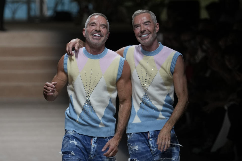 Designers Dean and Dan Caten walk on the catwalk at the end of the Dsquared2 men's Spring Summer 2024 collection presented in Milan, Italy, Friday, June 16, 2023. (AP Photo/Luca Bruno)