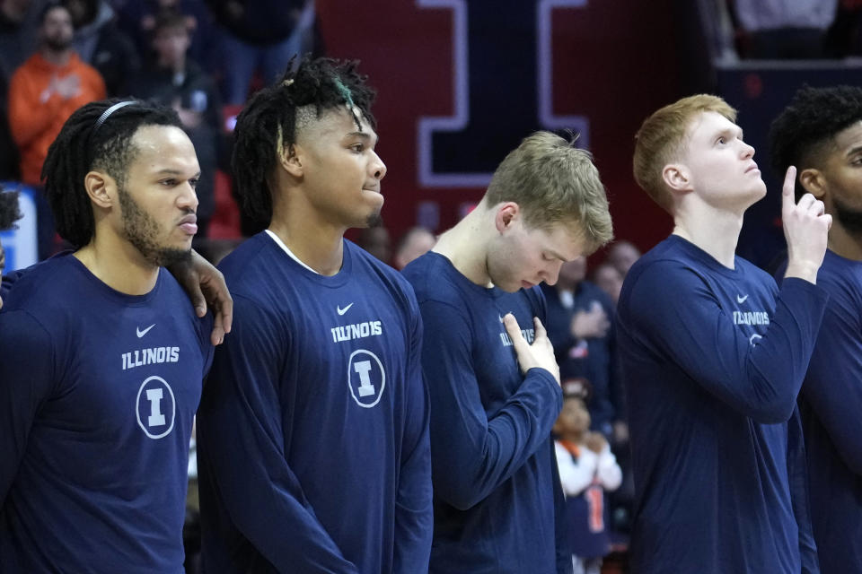 Illinois' Terrence Shannon Jr., second from left, stands with teammates, from left, Ty Rodgers, Marcus Domask, and Luke Goode during the national anthem before an NCAA college basketball game against Rutgers Sunday, Jan. 21, 2024, in Champaign, Ill. A federal judge has reinstated Shannon Jr., who had been suspended from the team since he was charged with rape in Kansas last fall. (AP Photo/Charles Rex Arbogast)