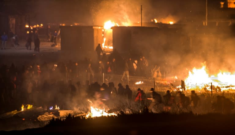 Migrants flee as a huge fire destroys the Grande-Synthe camp outside the northern French city of Dunkirk