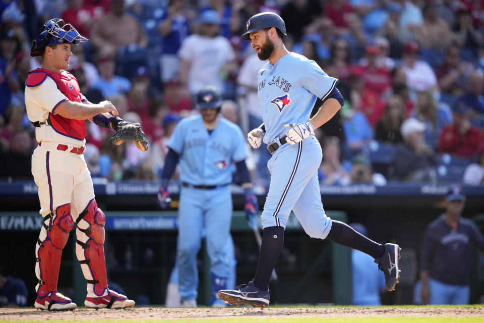 Toronto Blue Jays' Brandon Belt, right, rounds the bases past Philadelphia Phillies catcher J.T. Realmuto after hitting a home run during the fifth inning of a baseball game, Wednesday, May 10, 2023, in Philadelphia. (AP Photo/Matt Slocum)