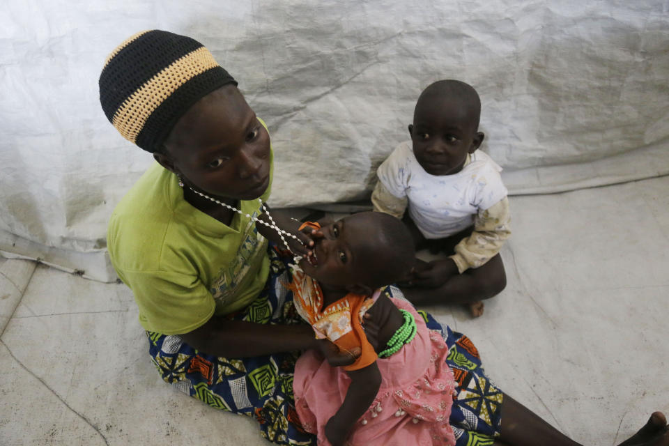 In this photo taken on Monday, Feb. 18, 2019, Lucy Ishaku, a woman displaced by Islamist extremist play with her children at there Malkohi camp in Yola, Nigeria. For those who live in the makeshift camp for Nigerians who have fled Boko Haram violence, the upcoming presidential vote isn’t a topic of conversation, because nearly all are more worried about putting food on the table.(AP Photo/ Sunday Alamba)