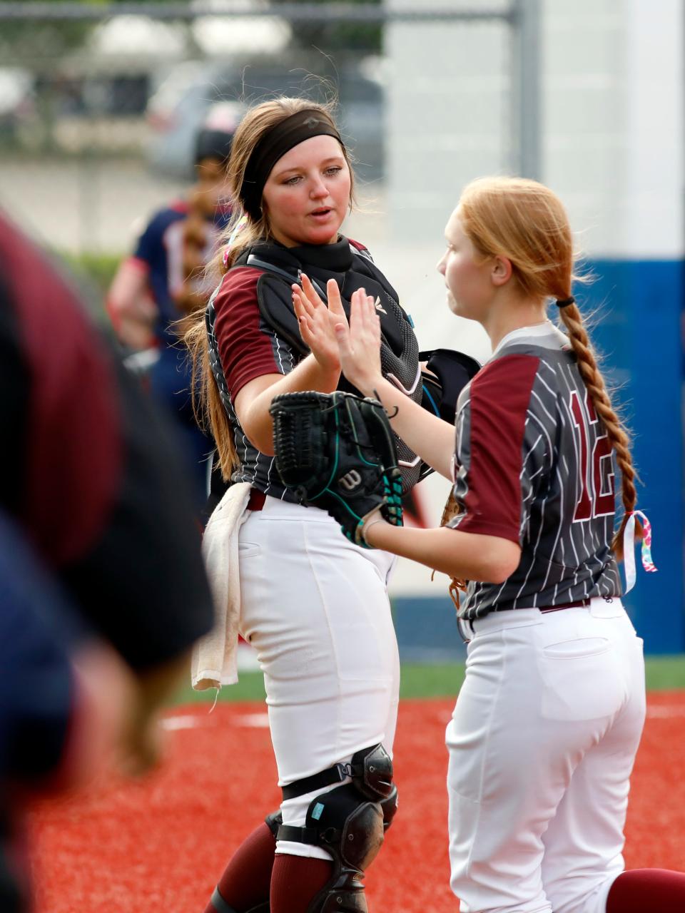 John Glenn senior Alivia Boothe greets freshman right fielder Bella Daniels after the latter made a running catch that led to a double play in a Division II district semifinal against Morgan on Monday at the Philo Athletic Complex in Duncan Falls. John Glenn won, 6-0, to reach its fourth straight district final.