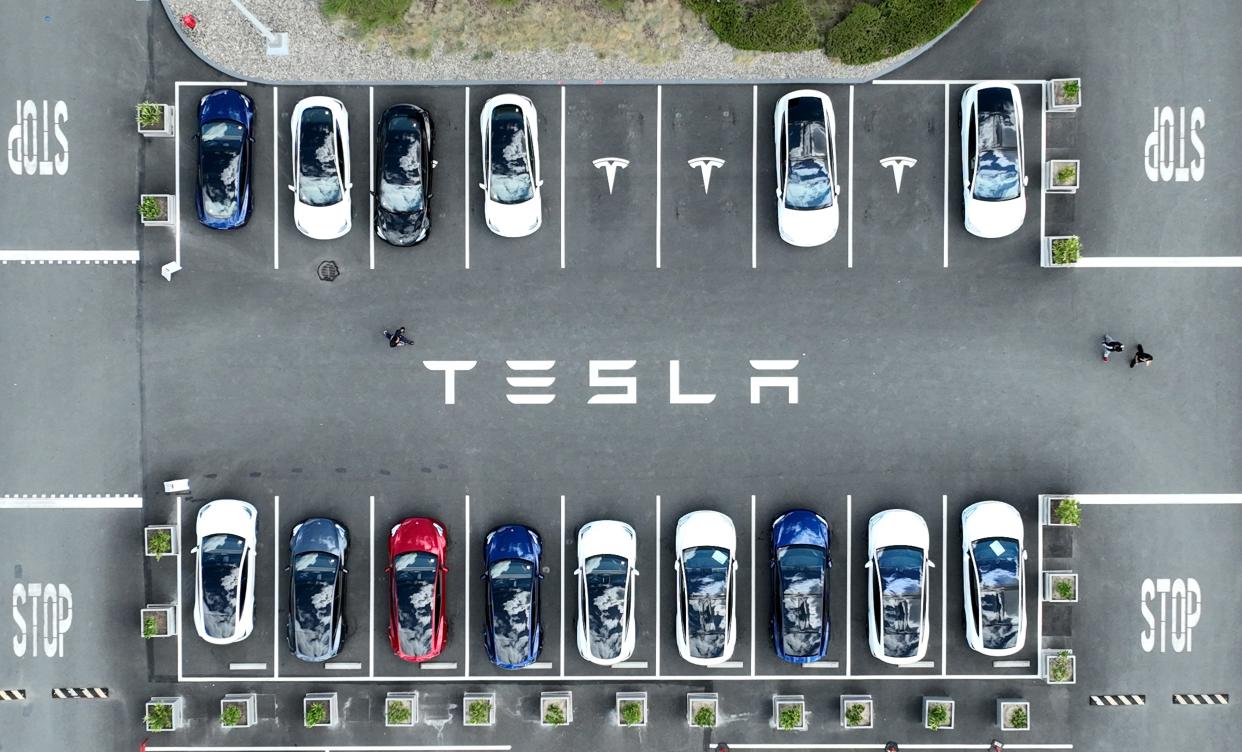 A group of Tesla cars sit in a parking lot near the company's factory in California.