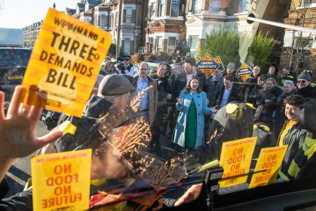 Liberal Democrat leader Jo Swinson speaks to Extinction Rebellion protesters dressed as bees after they glued themselves to the party’s battle bus during a visit to Knights Youth Centre in London 