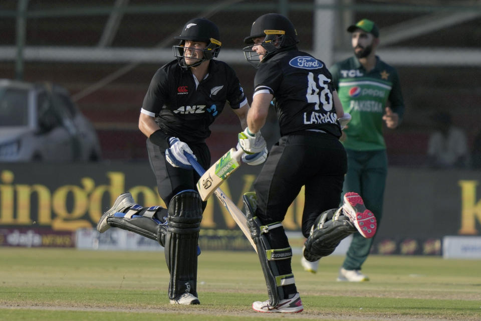 New Zealand's Mark Chapman, left, and Tom Latham, center, take a run during the fifth one-day international cricket match between New Zealand and Pakistan, in Karachi, Pakistan, Sunday, May 7, 2023. (AP Photo/Fareed Khan)