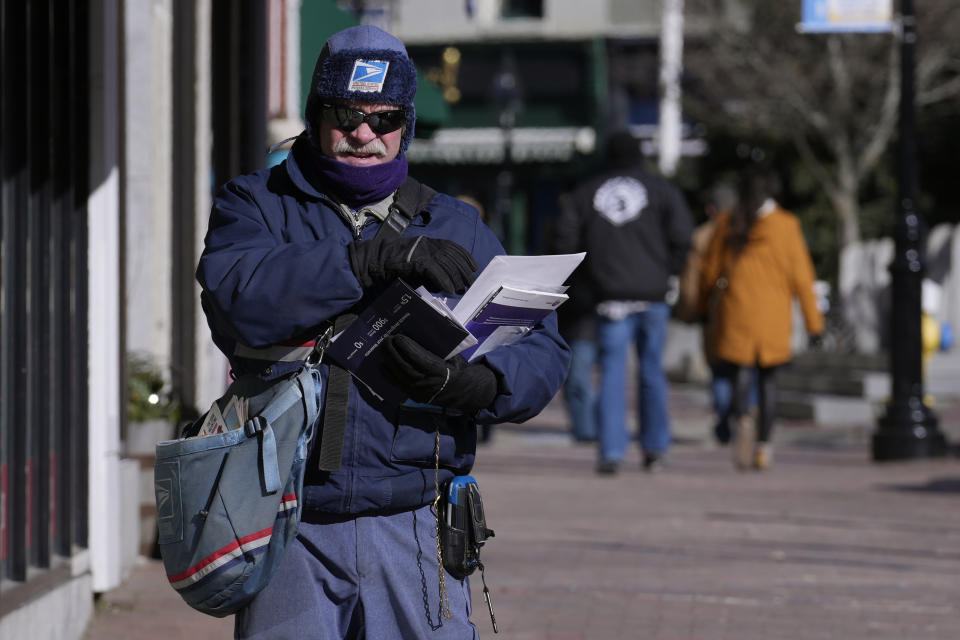 Letter carrier Dennis Devine is bundled up in winter clothing while making afternoon deliveries during a cold weather snap, Friday, Feb. 3, 2023, in Portsmouth, N.H. Windchills in New England are expected to be sub-zero on Friday and Saturday across the region. (AP Photo/Charles Krupa)