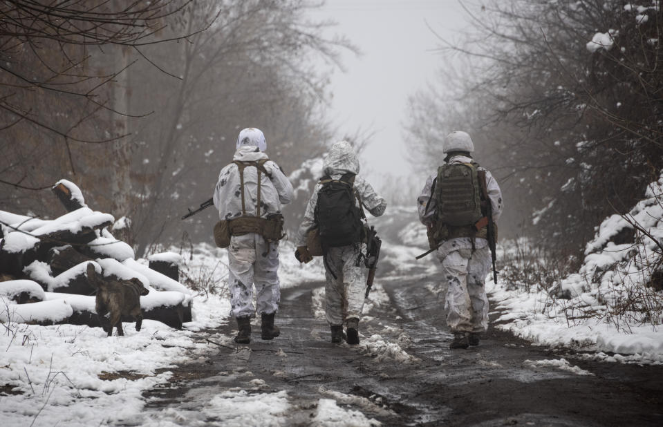 Ukrainian soldiers walks at the line of separation from pro-Russian rebels near Katerinivka, Donetsk region, Ukraine, Tuesday, Dec 7, 2021. Ukrainian authorities on Tuesday charged that Russia is sending tanks and snipers to the line of contact in war-torn eastern Ukraine to "provoke return fire," an accusation that comes amid fears that a Russian troop buildup near the Ukrainian border might indicate plans for an invasion. (AP Photo/Andriy Dubchak)