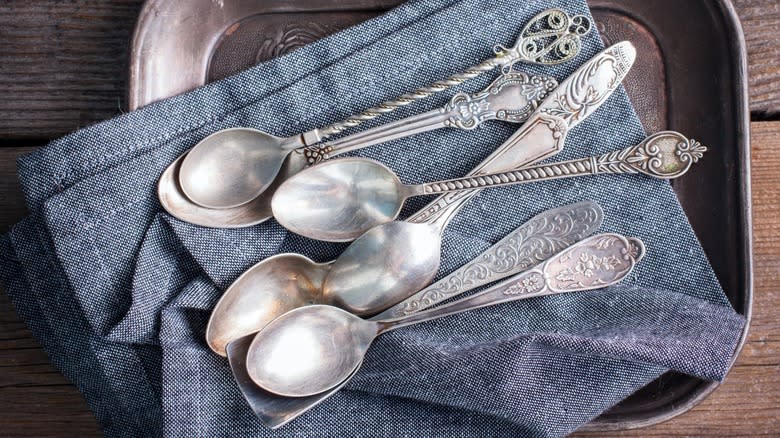 Antique silver spoons on a napkin