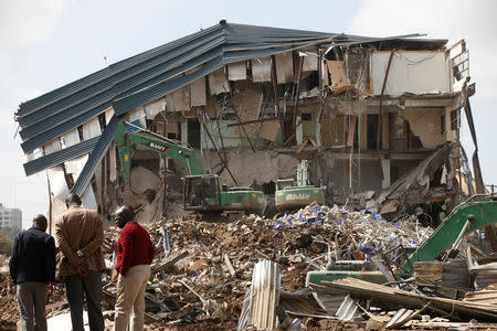 People watch as heavy machinery demolishes the UKAY Mall in Westlands, Nairobi, Kenya, August 14, 2018. REUTERS/Baz Ratner