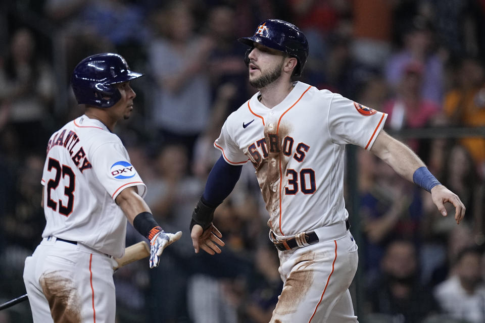 Houston Astros' Kyle Tucker (30) high-fives Michael Brantley (23) after scoring on a single by Jose Abreu during the fifth inning of a baseball game against the San Diego Padres, Saturday, Sept. 9, 2023, in Houston. (AP Photo/Kevin M. Cox)