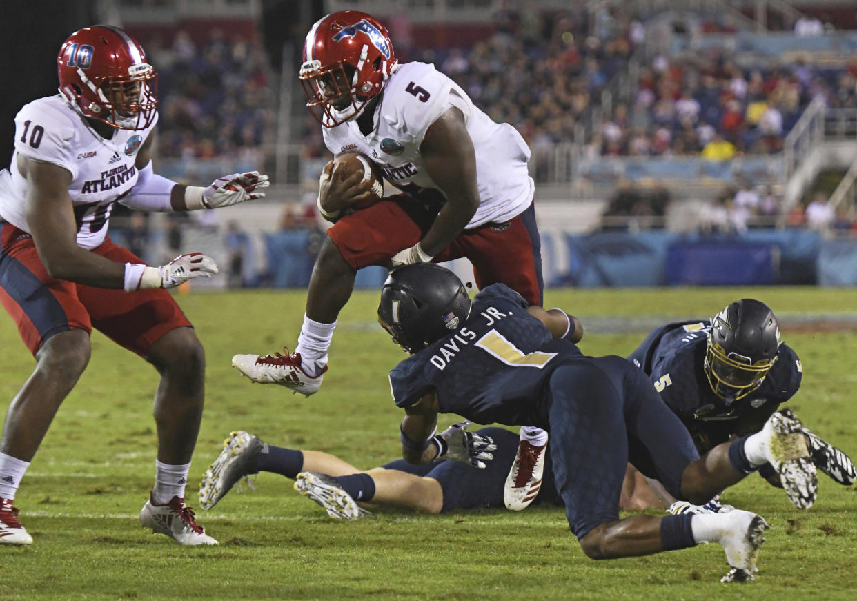 Florida Atlantic running back Devin Singletary (5) hurdles Akron cornerback Alvin Davis (1) on his way to the end zone in the second quarter of an NCAA college football game in the Boca Raton Bowl in Boca Raton, Fla., Tuesday, Dec. 19, 2017. (Jim Rassol/South Florida Sun-Sentinel via AP)