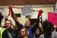 <p>A man tears up a confederate flag as supporters for and against a Fort Sanders Confederate memorial monument face off in Aug. 26, 2017 in Knoxville, Tenn. (Photo: Spencer Platt/Getty Images) </p>