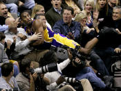 Los Angeles Lakers guard Kobe Bryant lands amongst fans after chasing down a loose ball in the second half of an NBA basketball game against the Dallas Mavericks in Dallas, Friday, Jan. 25, 2008. The Mavericks won 112-105. (AP Photo/Tony Gutierrez)