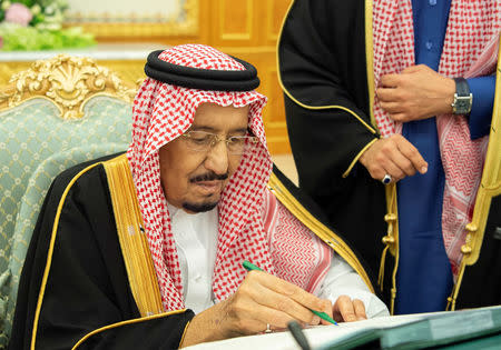 Saudi Arabia's King Salman bin Abdulaziz Al Saud signs documents during the 2019 budget meeting in Riyadh, Saudi Arabia December 18, 2018. Bandar Algaloud/Courtesy of Saudi Royal Court/Handout via REUTERS