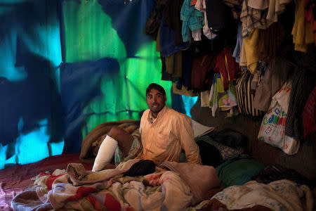 FILE PHOTO: Bangladeshi worker Mohamed, 25, is seen inside a tent following a shooting incident in the of town of Manolada, Greece, April 18, 2013. REUTERS/Giorgos Moutafis/File Photo