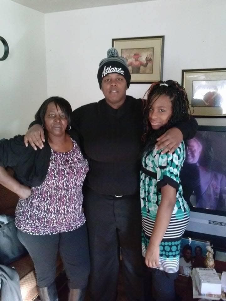 Takeysha Kirk, center, poses for a photo with her mother Rosier Burks, left, and her younger sister Tera Burks, right.