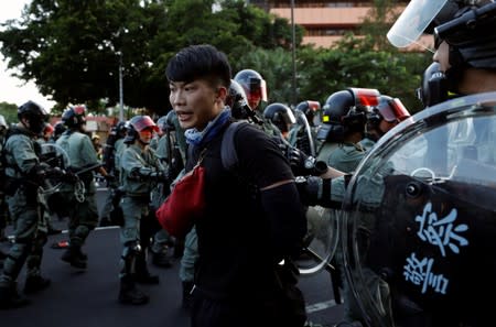 Police officers detain an anti-government protester in Sha Tin