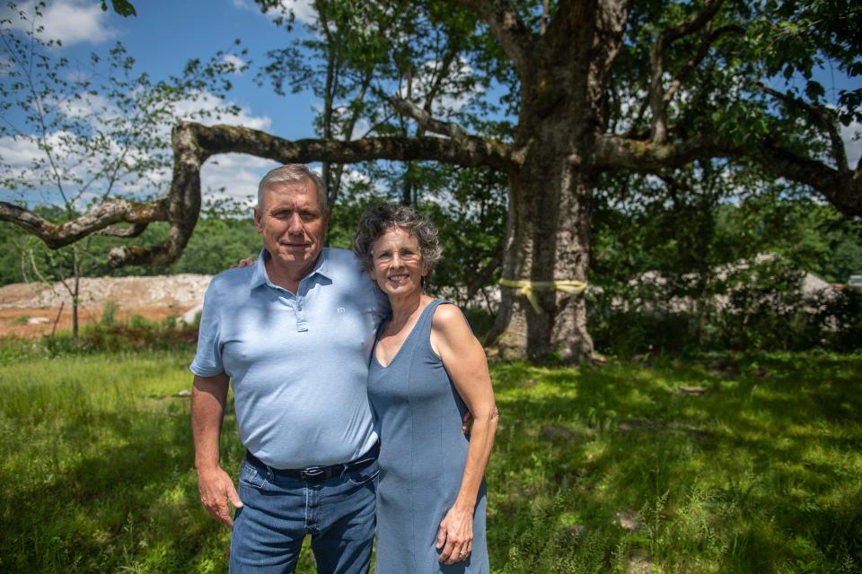 John Waits and Ruth Osburn stand near a 340-year-old tree in Arrington, Tenn., Wednesday, May 17, 2023. Waits, the developer of a new housing development, reworked the plans to save the tree. The Williamson County Planning Commission approved the reworked plans earlier this year.