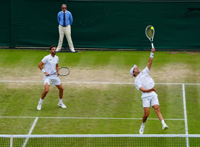 El marplatense Horacio Zeballos ejecuta un smash en la semifinal de Wimbledon que junto al español Marcel Granollers Pujol les ganó al italiano Simone Bolelli y al tandilense Máximo González.