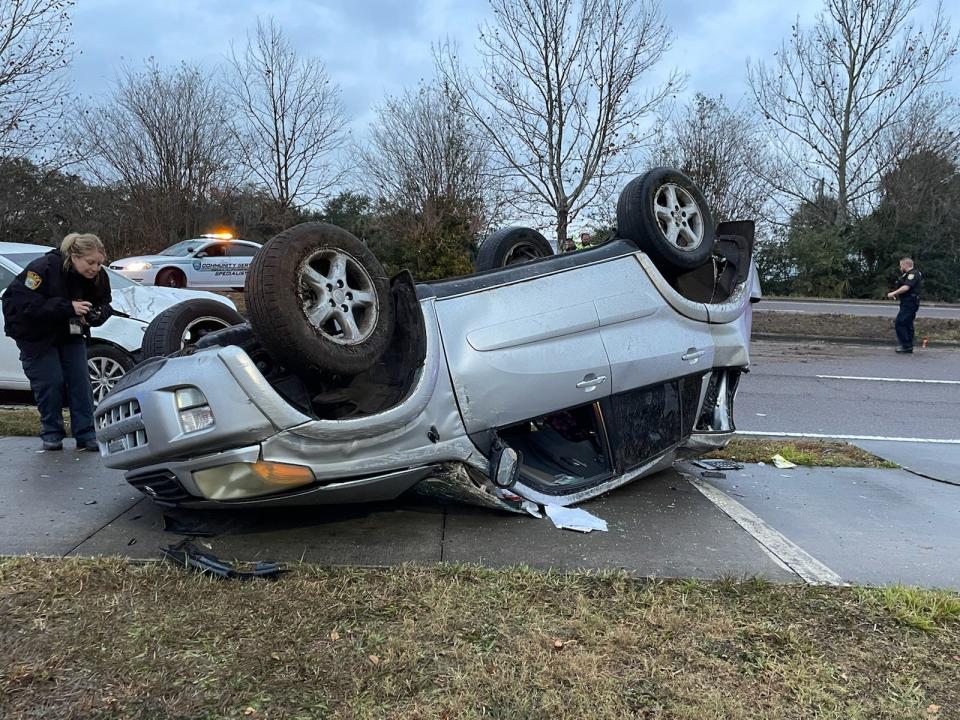 An Ocala Police Department evidence technician takes picture of an overturned SUV involved in a three-vehicle wreck on Tuesday