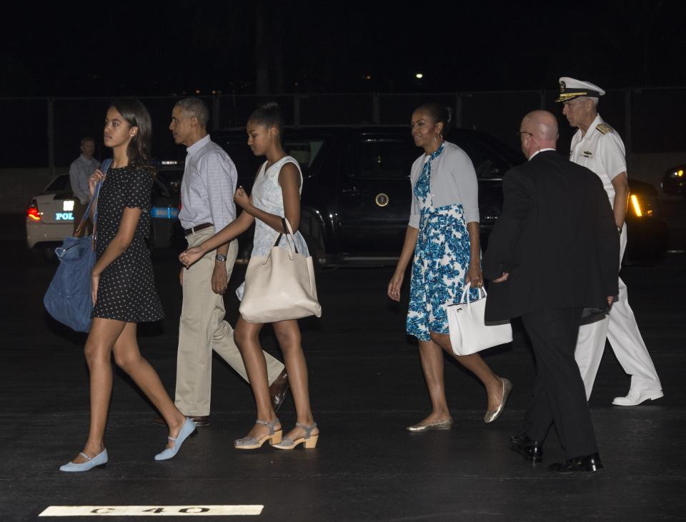 President Barack Obama, first lady Michelle Obama and daughters Malia and Sasha arrive at Joint Base Pearl Harbor-Hickam in Honolulu on December 19, 2014, at the start of their annual Christmas vacation in Hawaii.