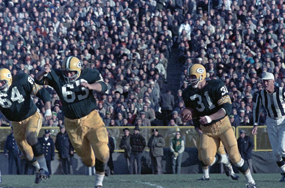 Green Bay Packers guard Jerry Kramer (64) and Fuzzy Thurston (63) lead fullback Jim Taylor (31) on the sweep during Green Bay’s 17-13 victory over the Baltimore Colts at new City Stadium on Nov. 18, 1962. Press-Gazette archives