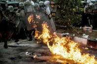 Riot police officers react as a molotov cocktail explodes nearby during a clash with student protesters in Bandung, West Java, Indonesia, Monday, Sept. 30, 2019. Thousands of Indonesian students resumed protests in several cities on Monday against a new law they say has crippled the country's anti-corruption agency, with some clashing with police. (AP Photo/Kusumadireza)