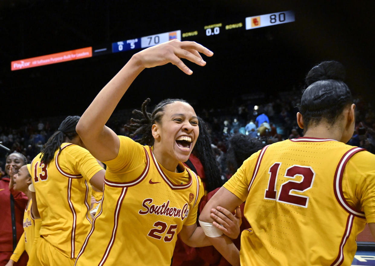 Southern California guard McKenzie Forbes (25) and teammates celebrate an overtime win against UCLA in an NCAA college basketball game in the semifinals of the Pac-12 women's tournament Friday, March 8, 2024, in Las Vegas. (AP Photo/David Becker)