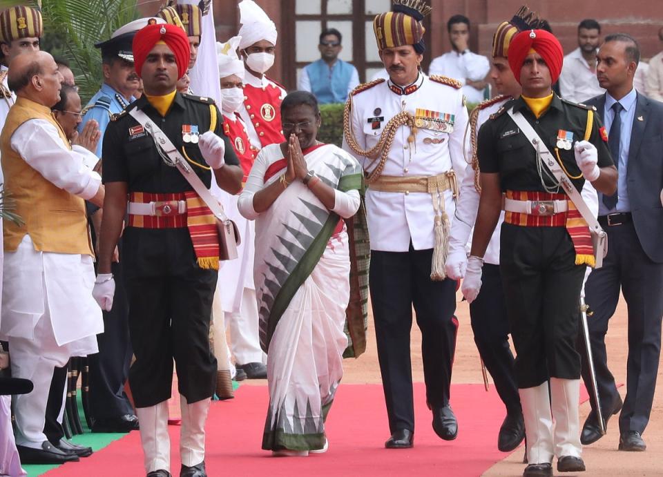 India's new president Draupadi Murmu (centre) greets well wishers as she arrives during her welcome ceremony (EPA)